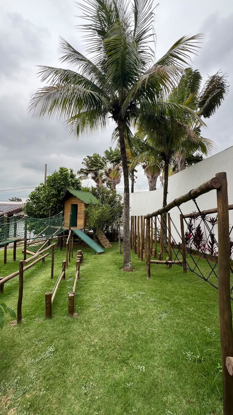 Playground com escorregador entre coqueiros